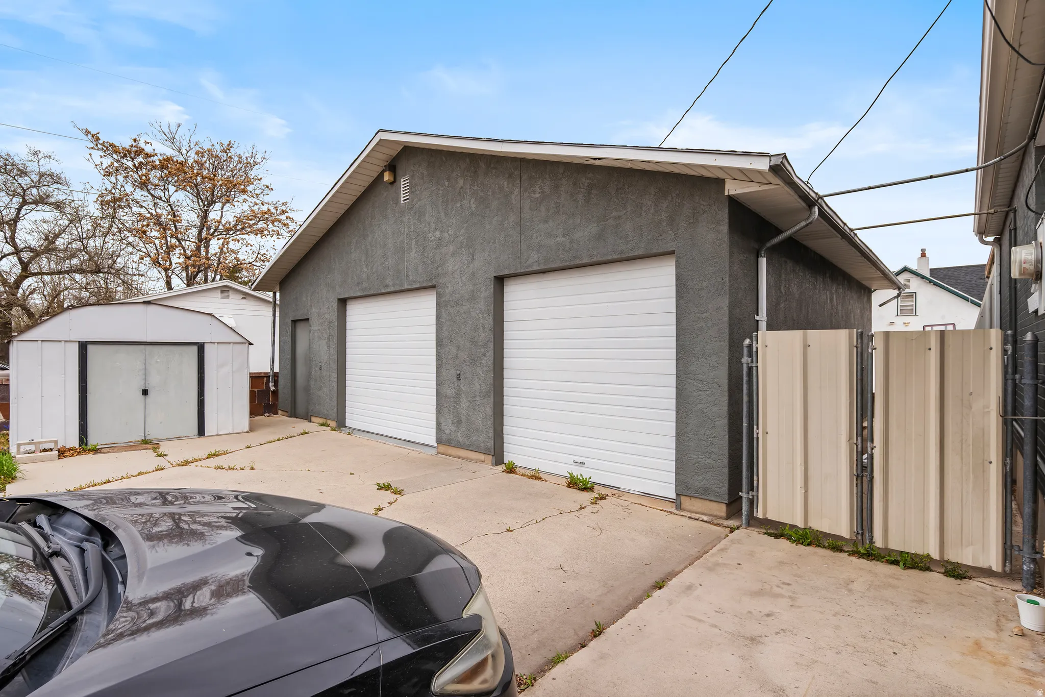 Detached garage with a gate and a storage shed