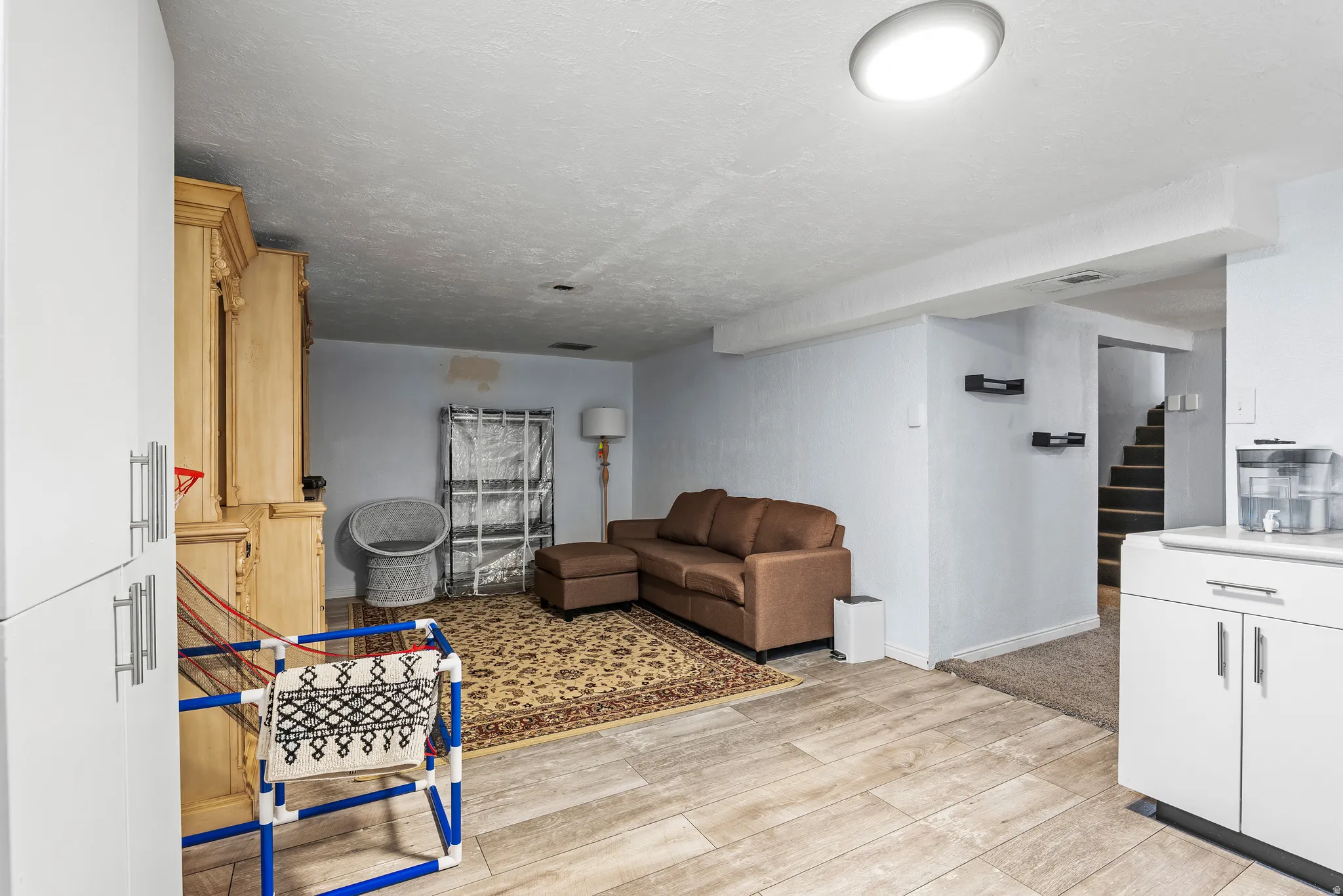 Living area featuring light wood-style floors and a textured ceiling