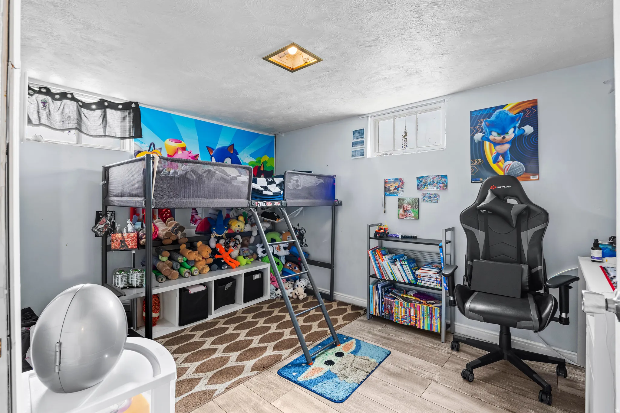 Bedroom with light wood-style floors and a textured ceiling