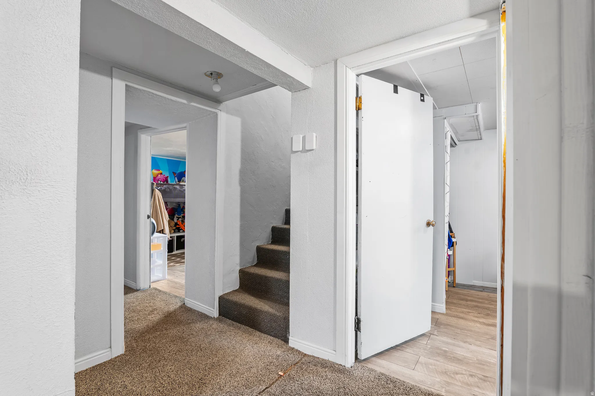 Hallway featuring baseboards and light carpet