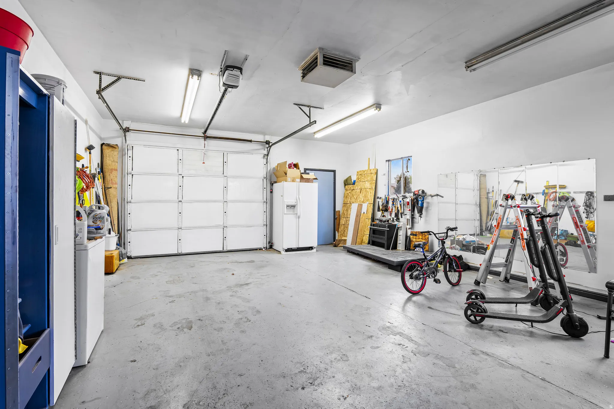 Garage with white fridge with ice dispenser and a heating unit