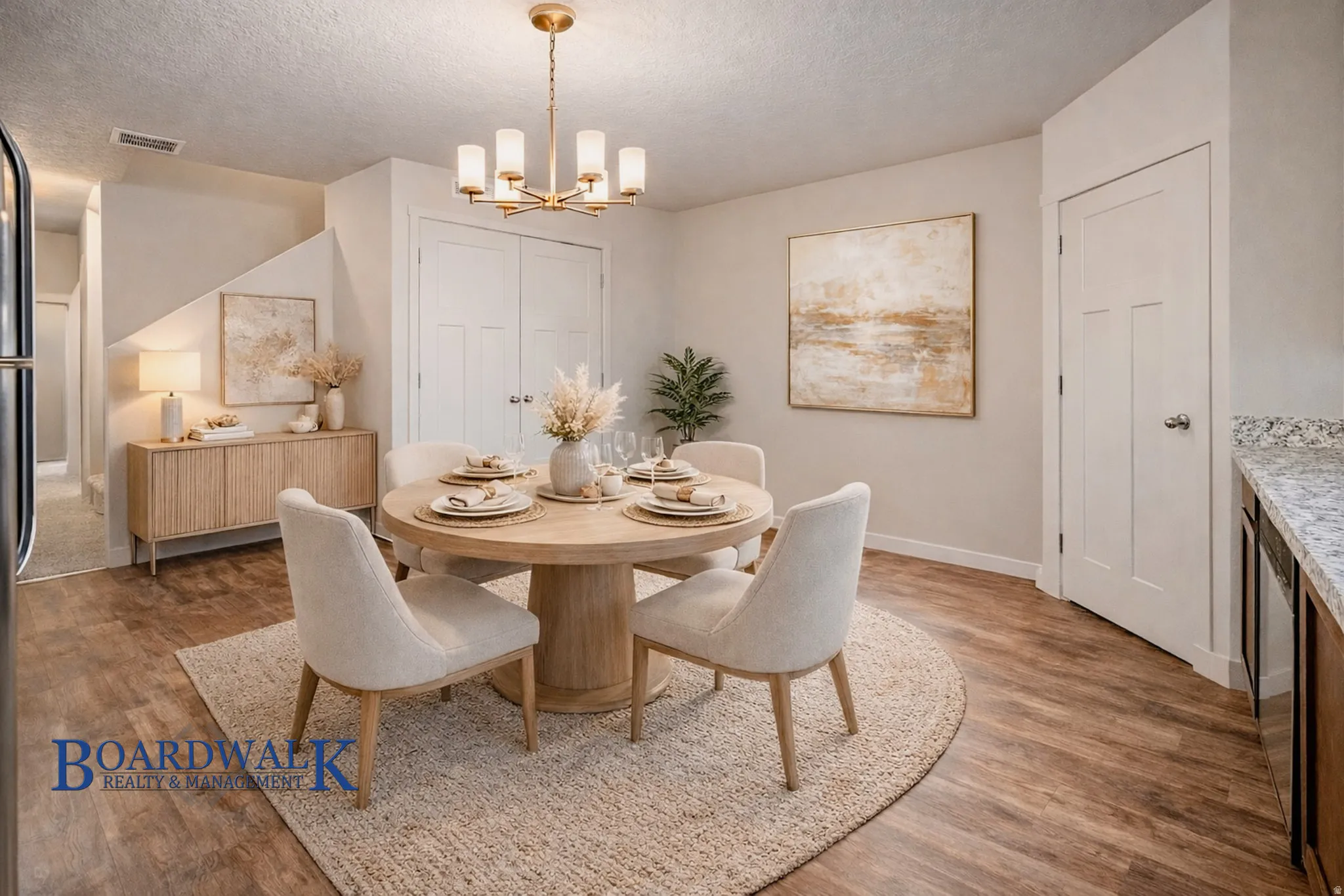 Dining room with light wood finished floors, hanging lights, and a textured ceiling
