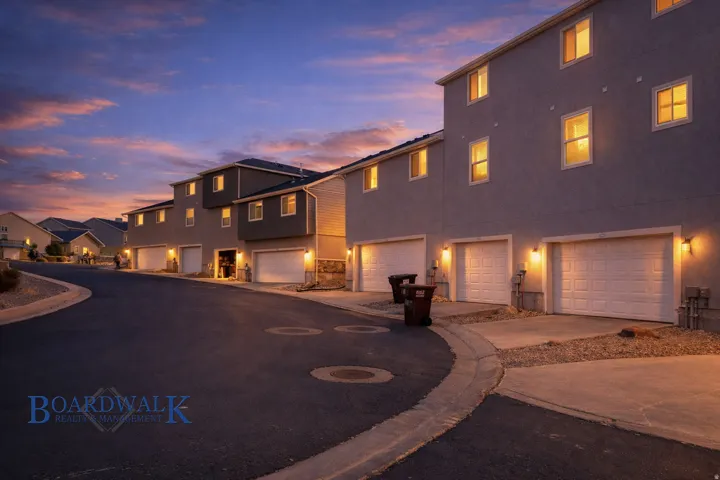 View of front of home with a garage, a residential view, stucco siding, and concrete driveway