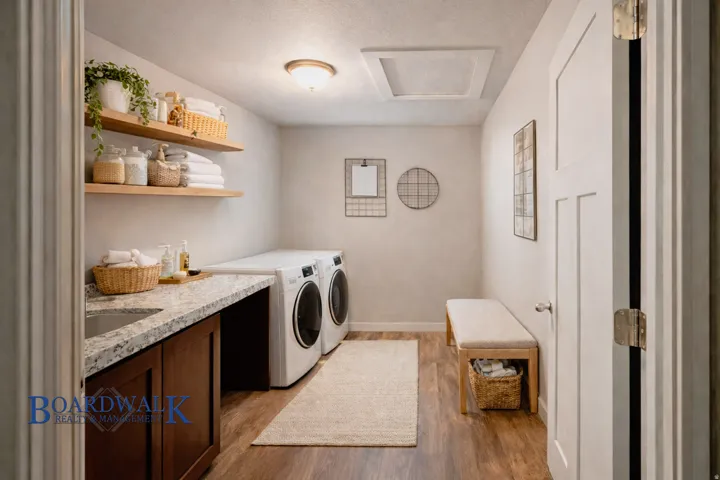 Laundry room featuring light wood-style flooring, independent washer and dryer, and a textured ceiling