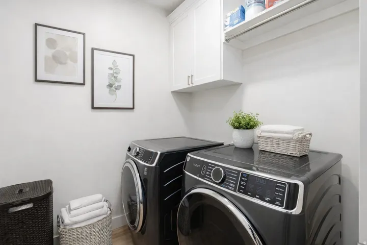 Laundry room featuring washing machine and clothes dryer and cabinet space