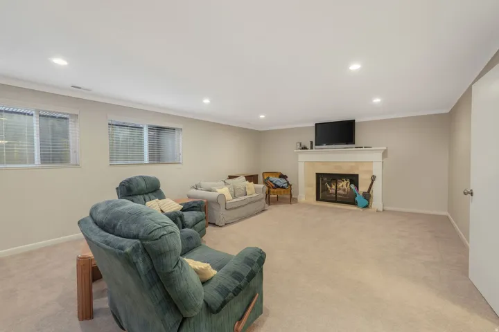 Living area featuring a fireplace, vaulted ceiling, and recessed lighting