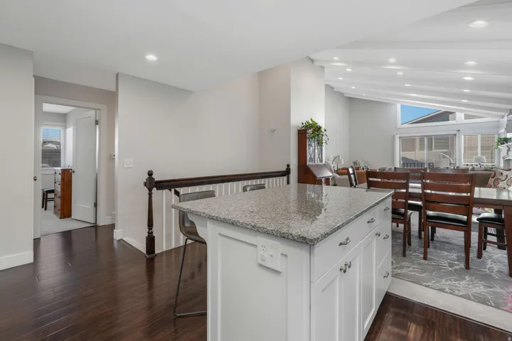 Kitchen with white cabinetry, stainless steel appliances, dark stone countertops, and tasteful backsplash