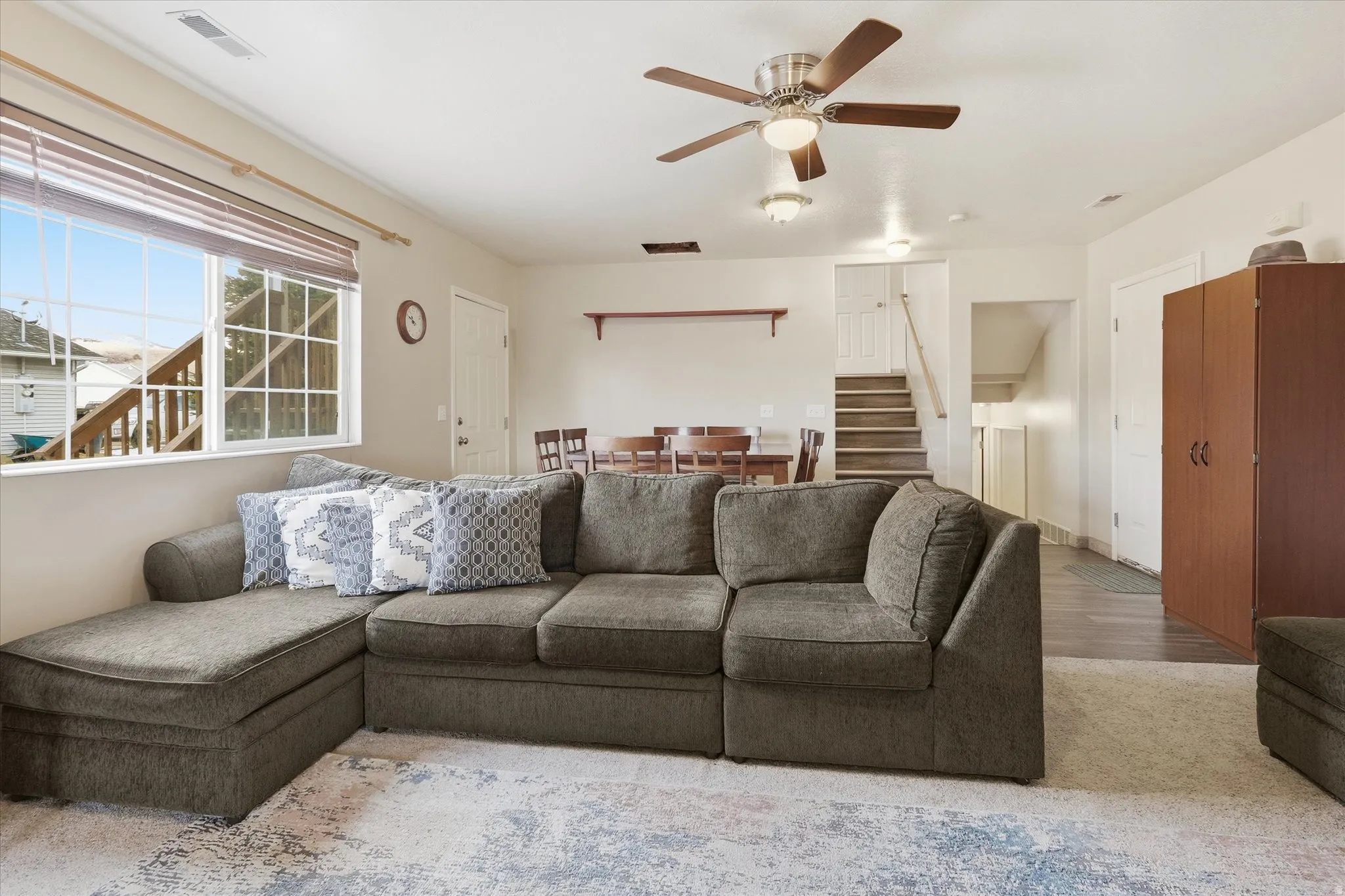 Living room with stairway and a ceiling fan