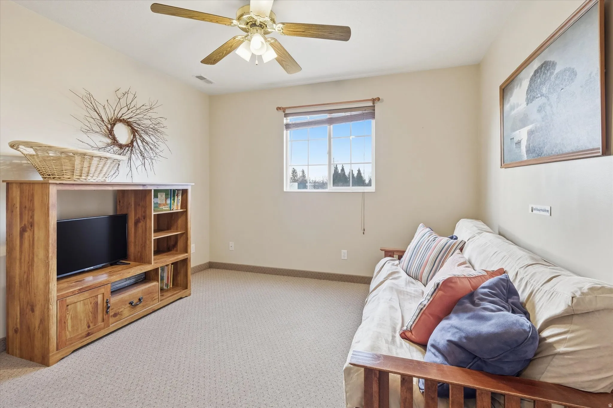 Living area with light carpet and ceiling fan