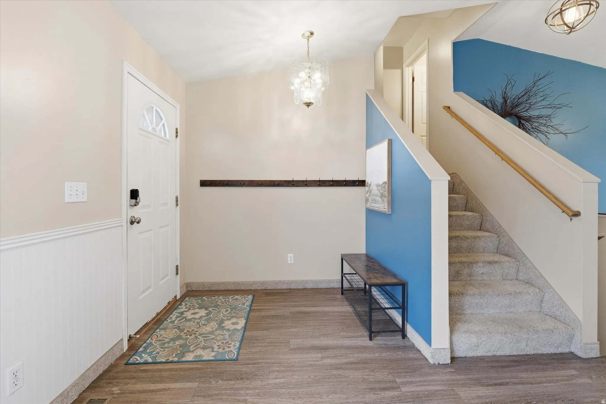 Entryway featuring suspended lighting, wood finished floors, and lofted ceiling