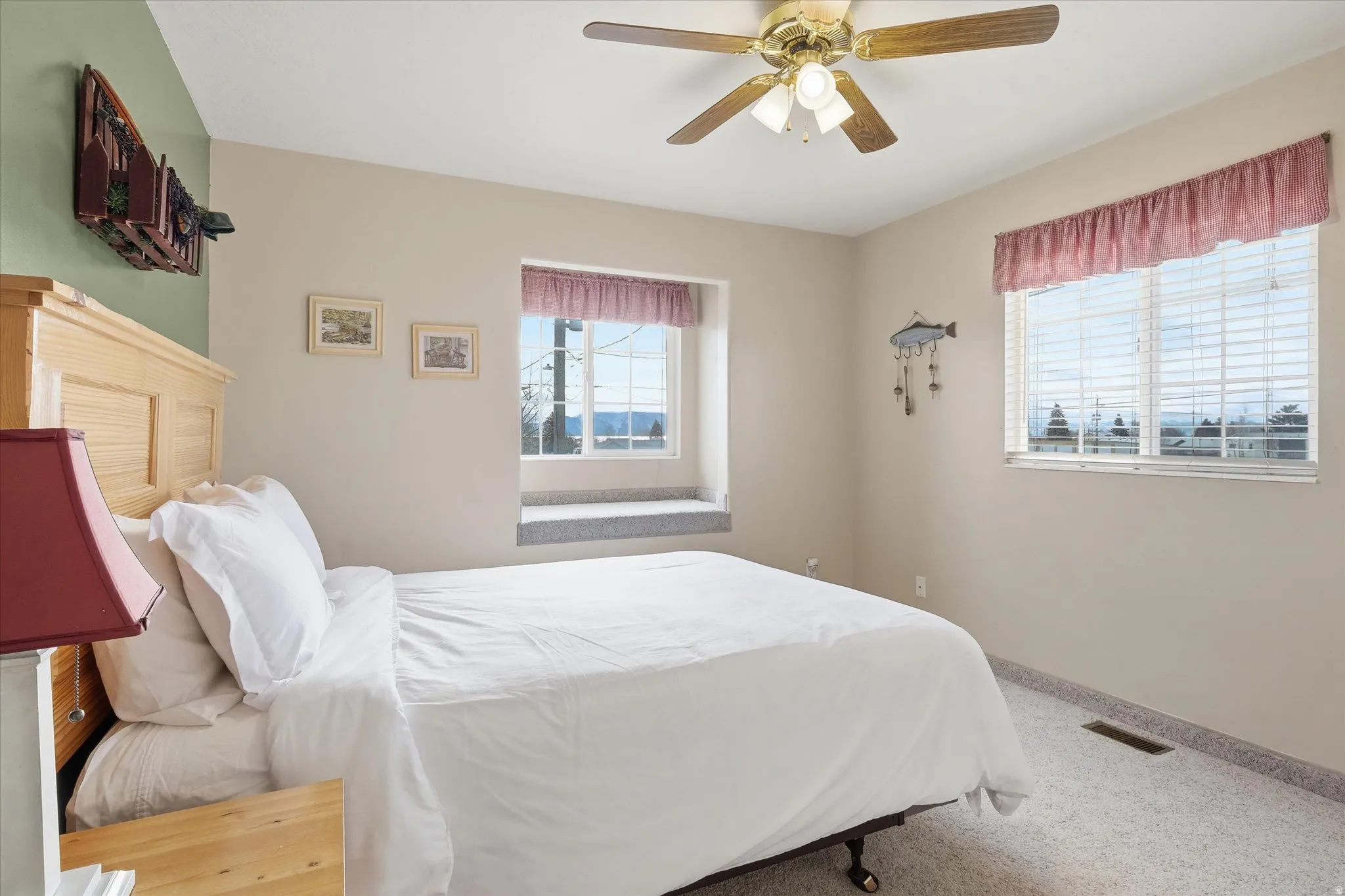 Carpeted bedroom with a ceiling fan and baseboards