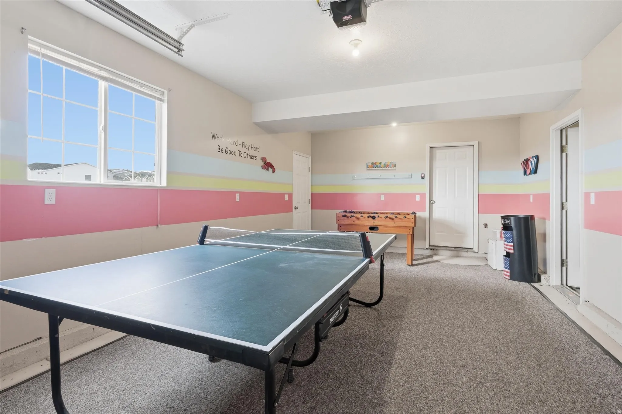 Recreation room featuring carpet and a garage