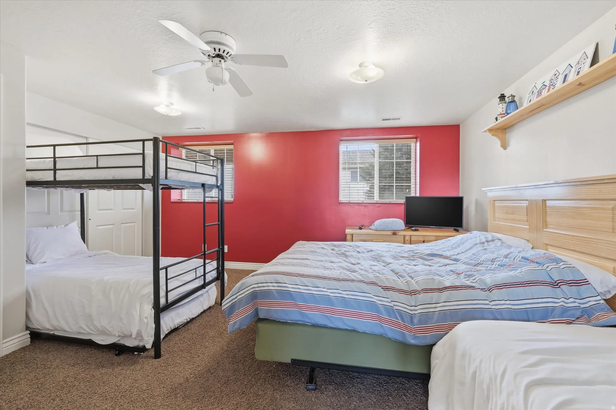 Bedroom with carpet floors, ceiling fan, and a textured ceiling