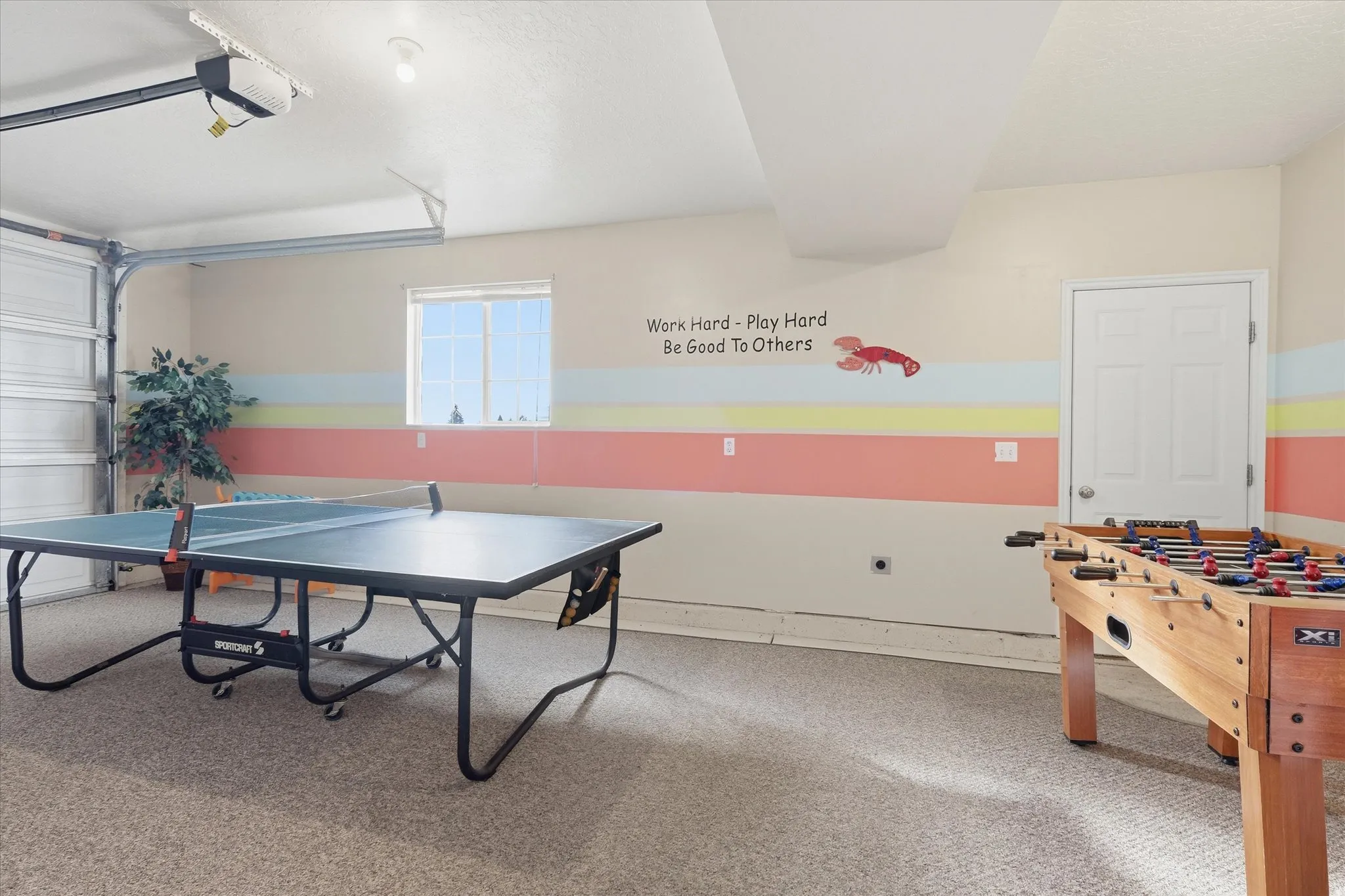 Game room with a garage, light colored carpet, and a textured ceiling