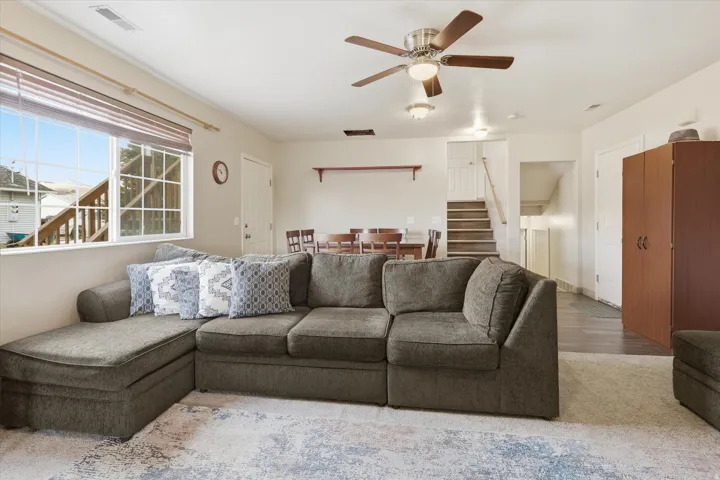 Living room with stairway and a ceiling fan