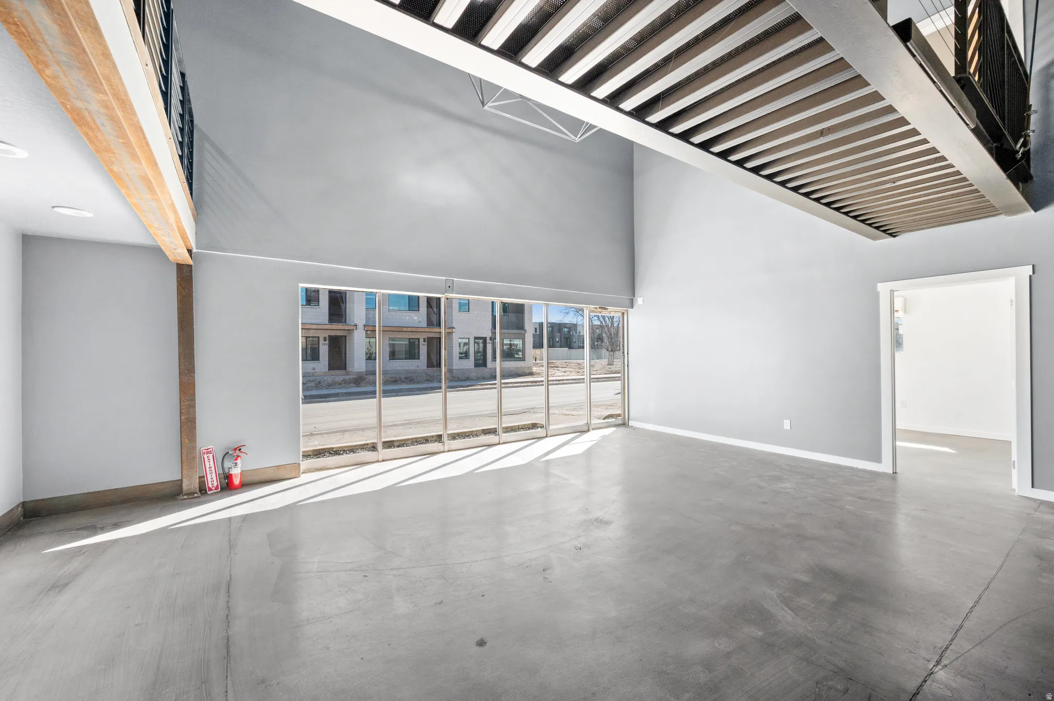 Unfurnished room with concrete flooring and a high ceiling