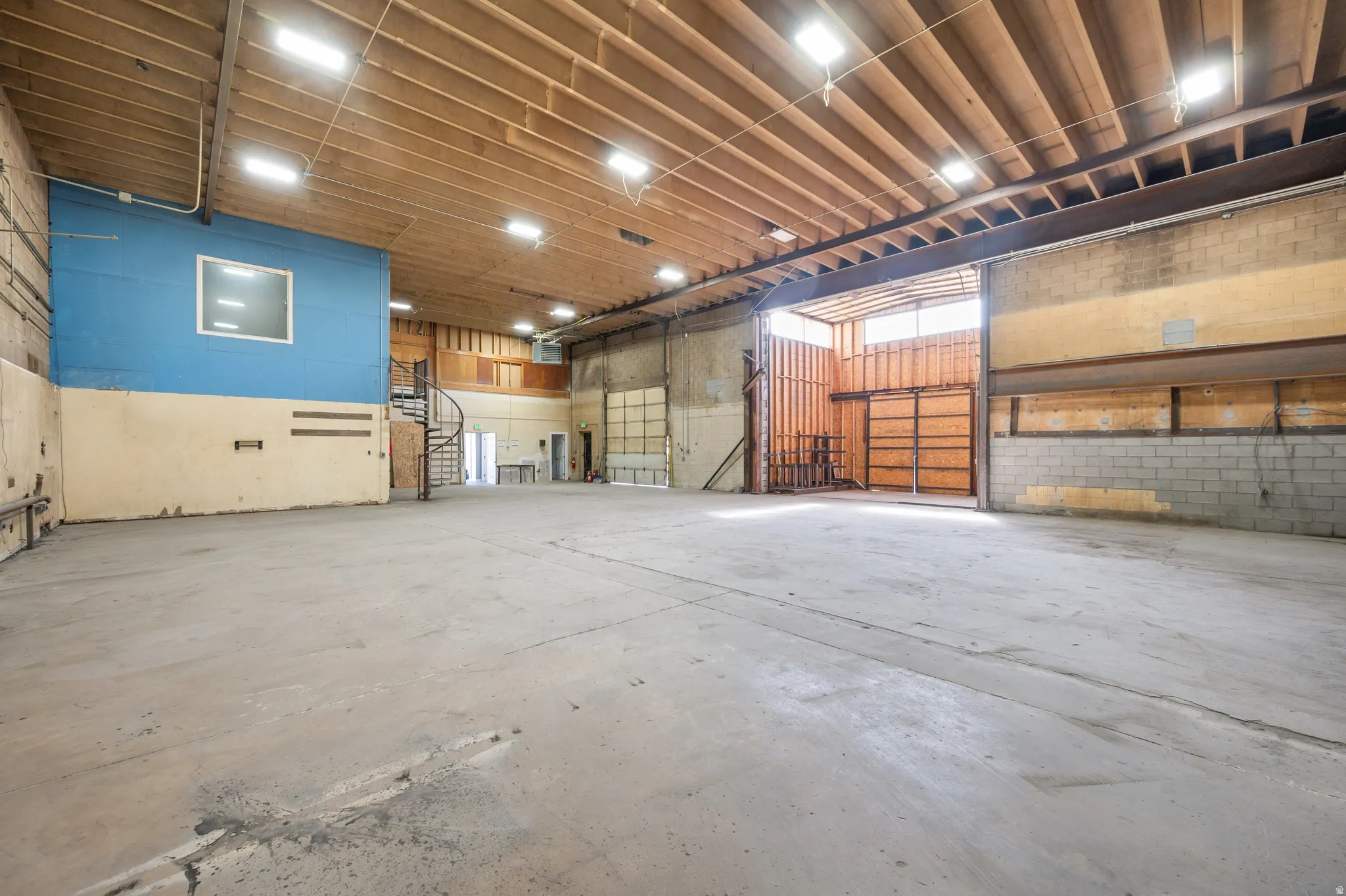 Miscellaneous room featuring concrete flooring, a garage, and a heating unit