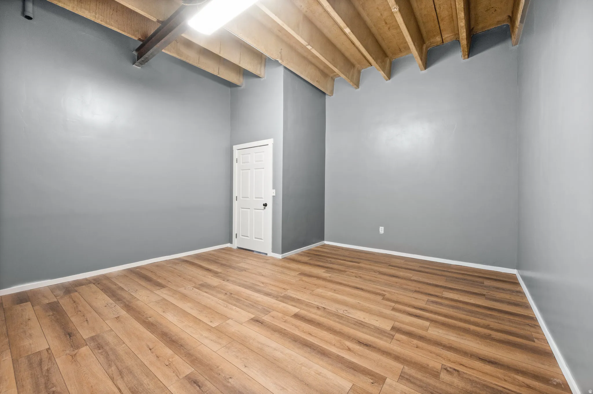 Empty room with baseboards and light wood-type flooring