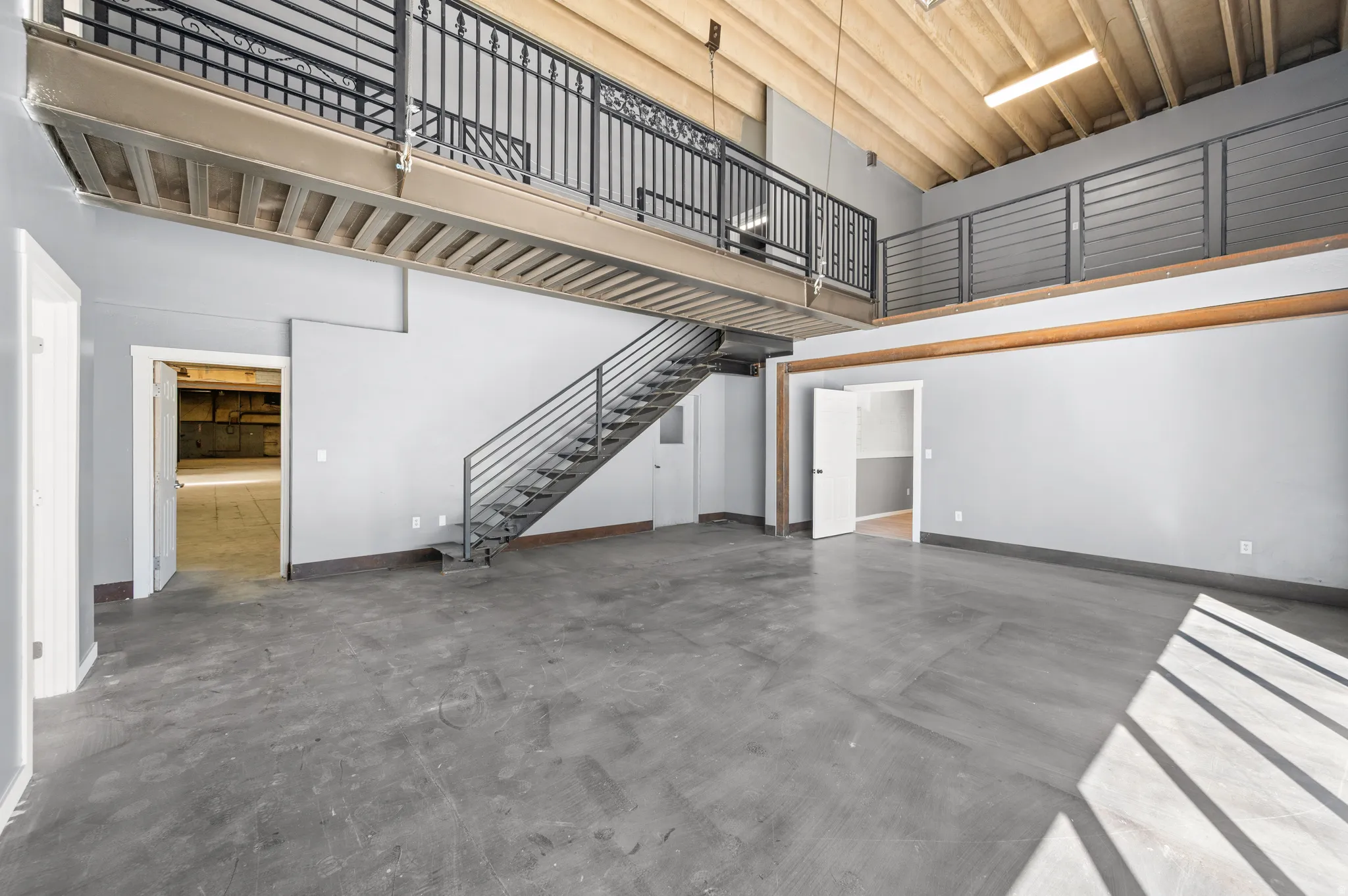 Unfurnished living room with finished concrete flooring and a high ceiling