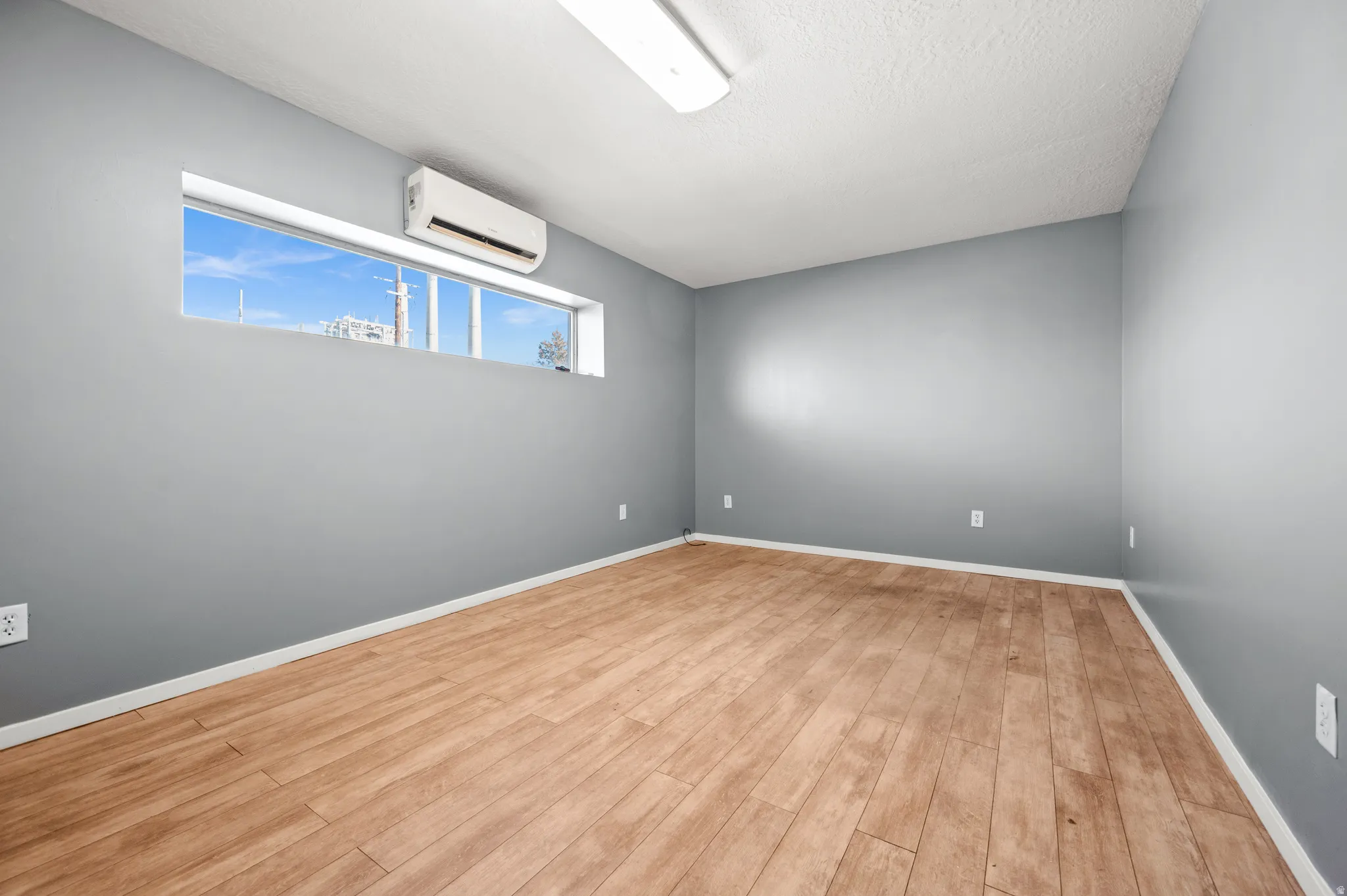 Spare room with light wood-type flooring and a mini split for heating / cooling