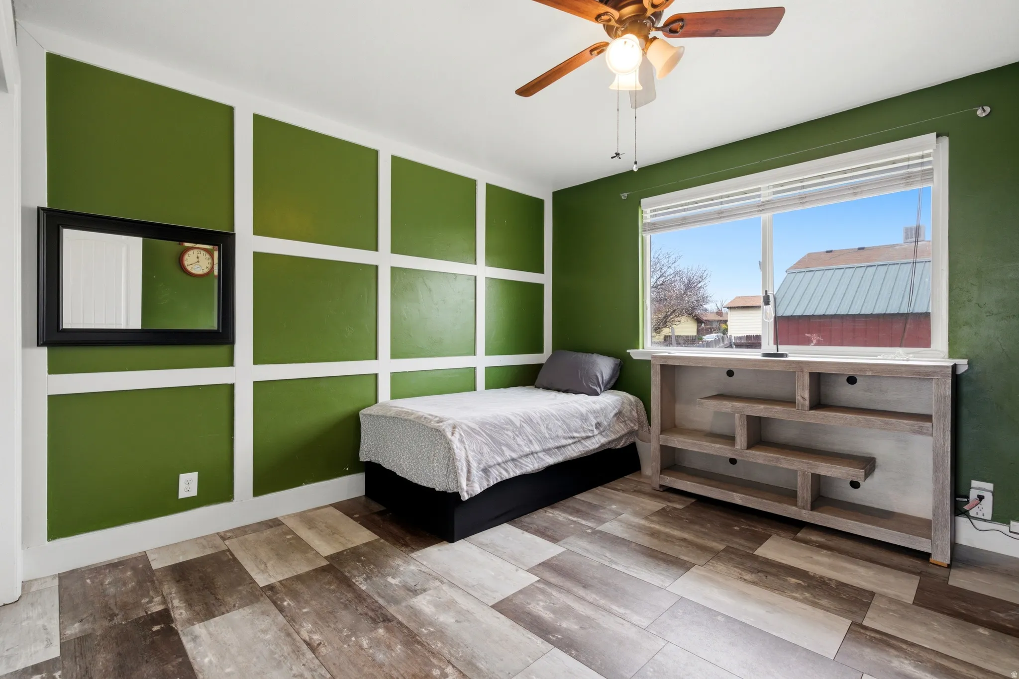 Primary bedroom with accent wall and ceiling fan.