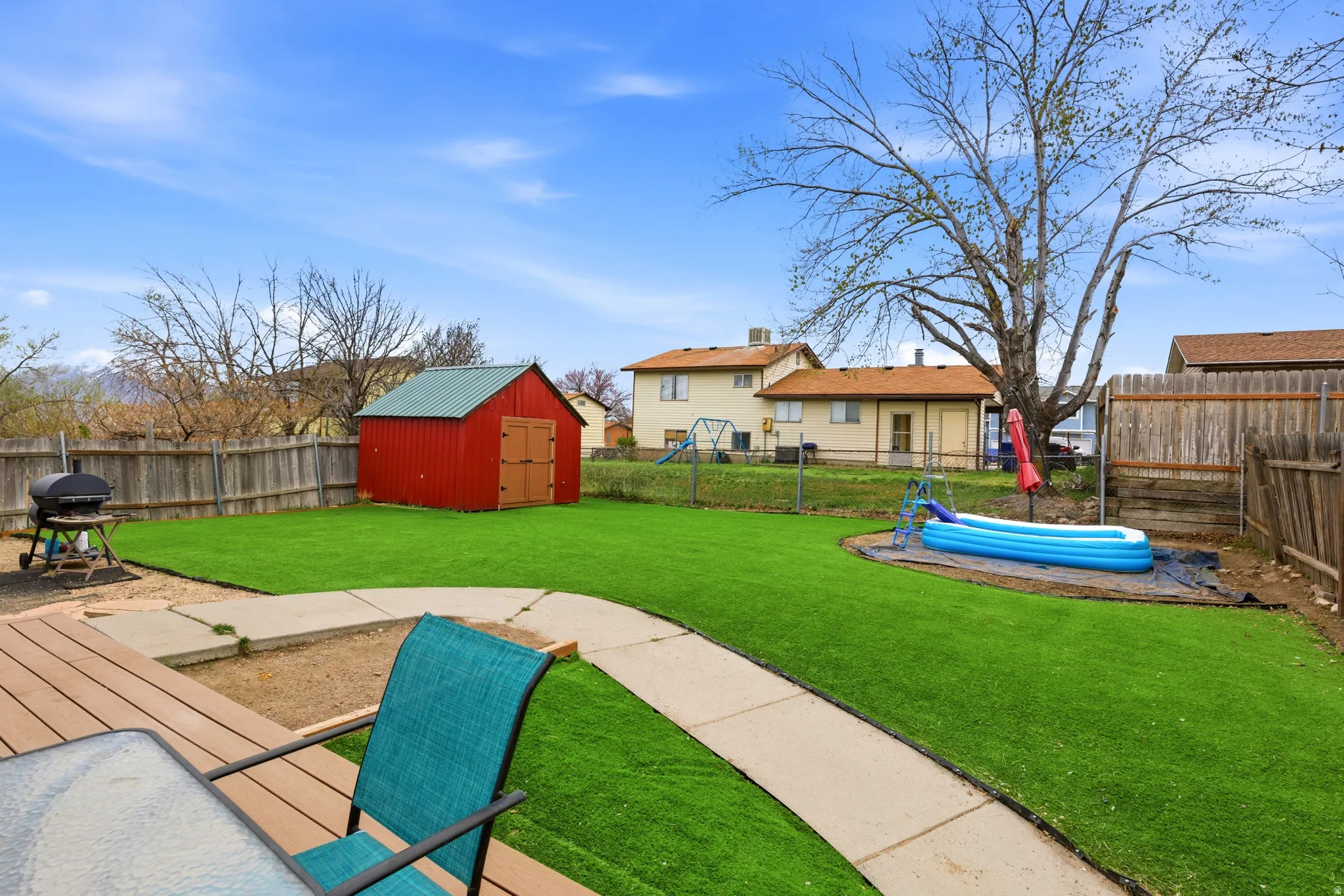 Xeriscaped Backyard with deck and metal exterior shed.