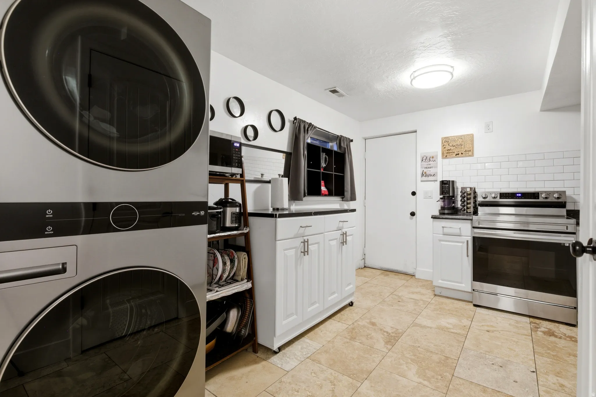 Laundry area with stacked washer/dryer in basement kitchen