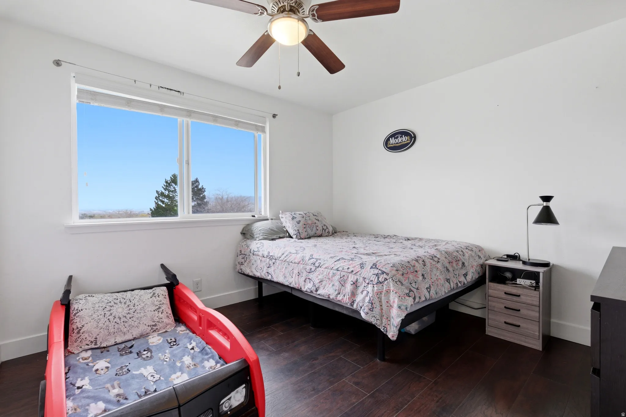 Bedroom with dark wood finished floors and a ceiling fan