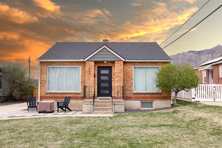 View of front of house featuring roof with shingles and brick siding