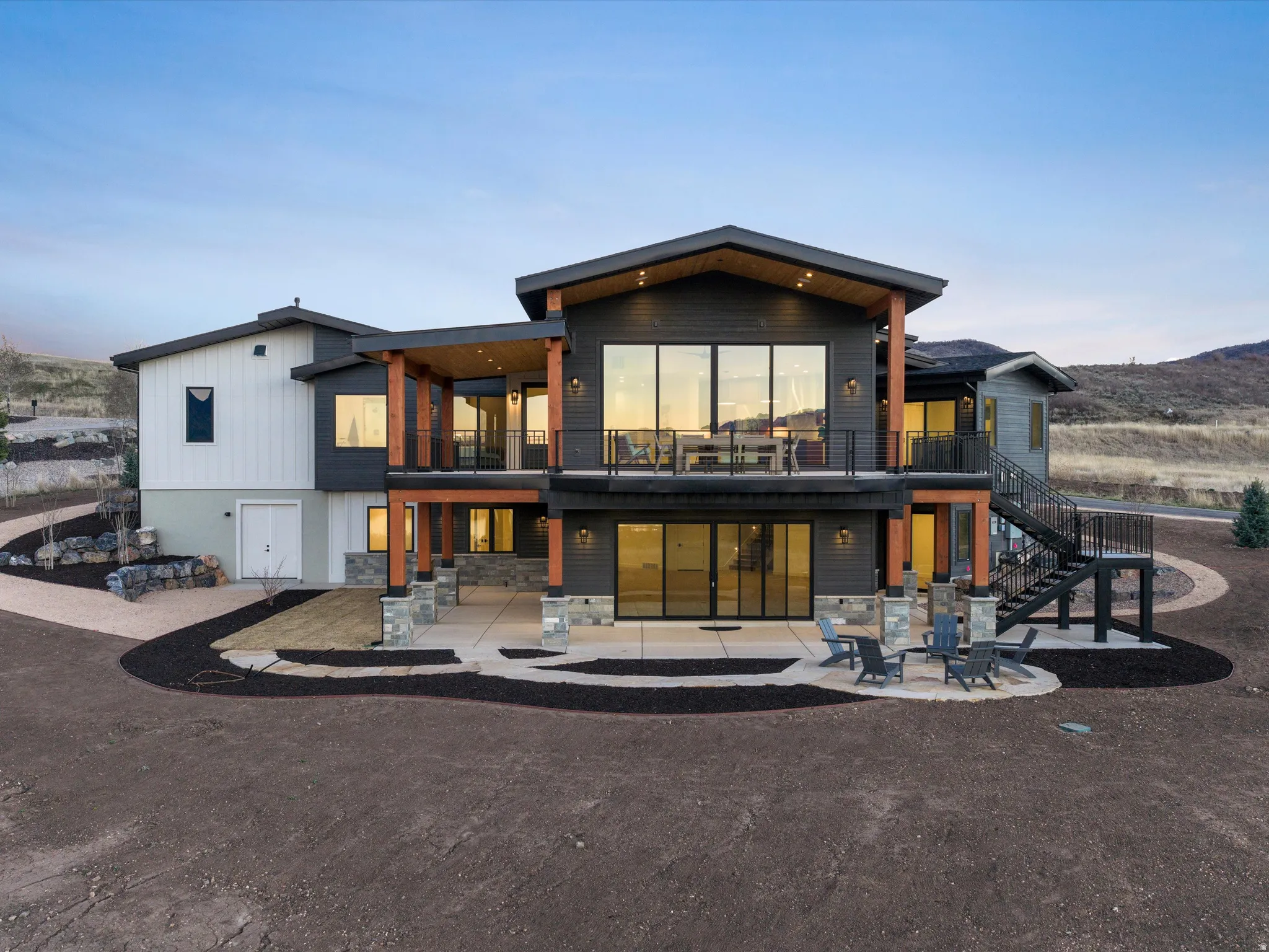 Rear view of property with a balcony and stone siding