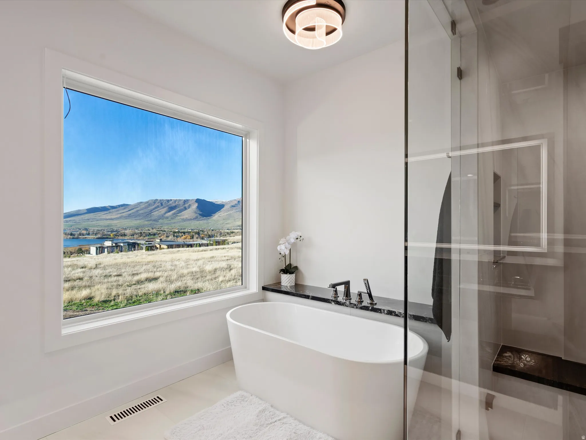 Bathroom with a mountain view, a freestanding bath, and a stall shower