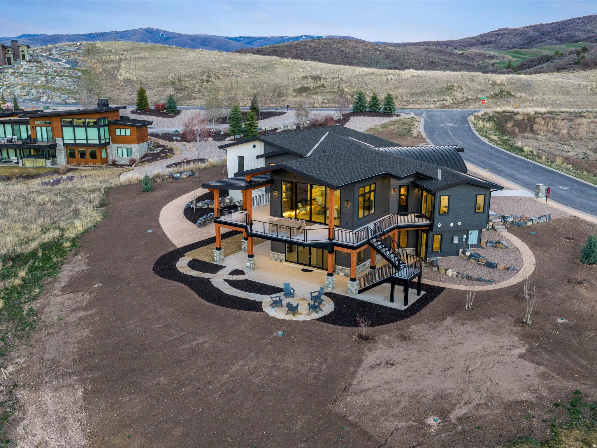 Back of property with a balcony, a patio, a mountain view, and roof with shingles