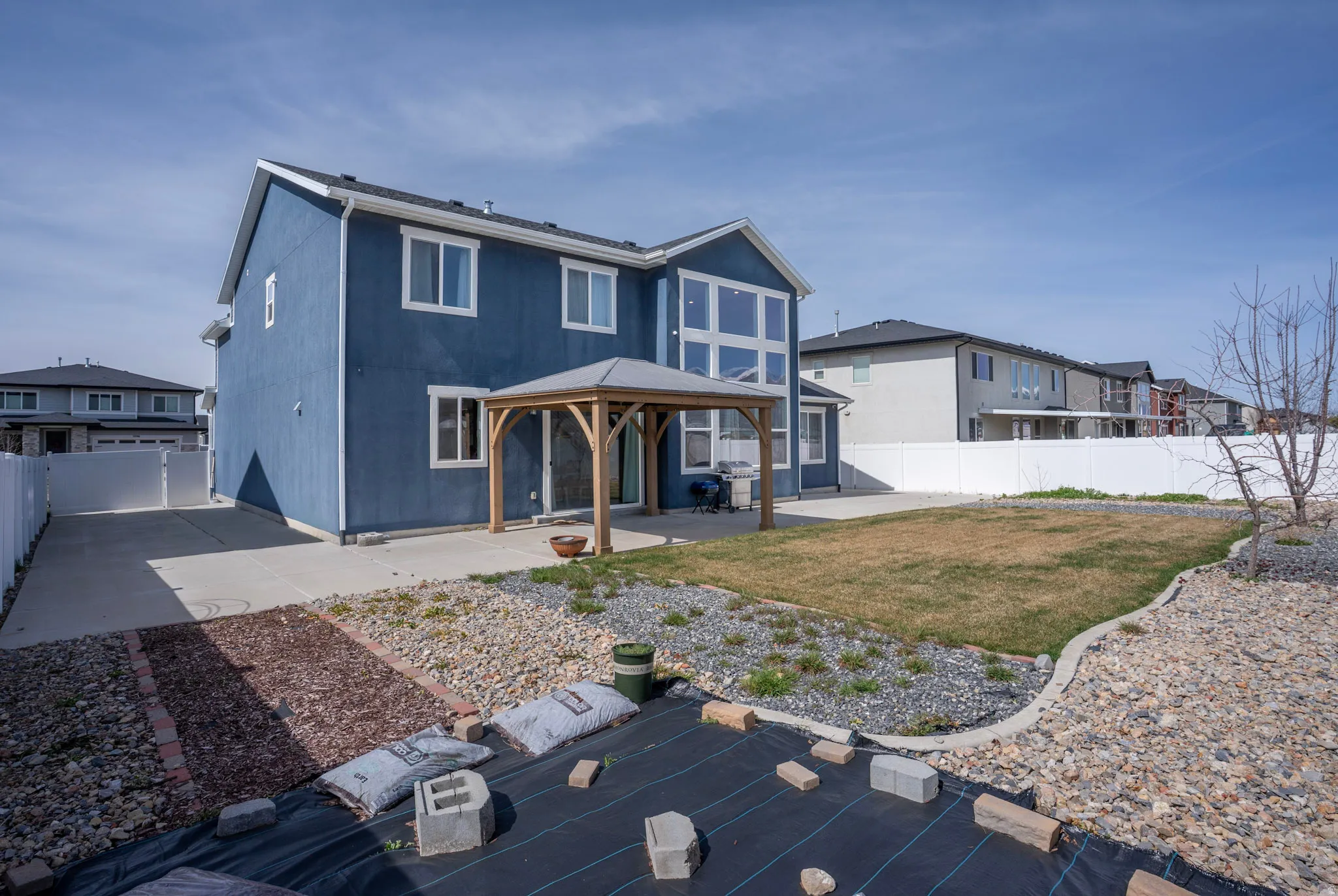 Rear view of house featuring a gazebo, a patio area, a fenced backyard, and a residential view