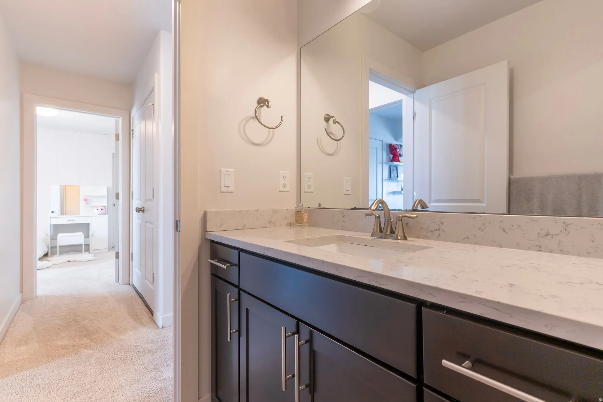Bathroom featuring vanity and light carpet