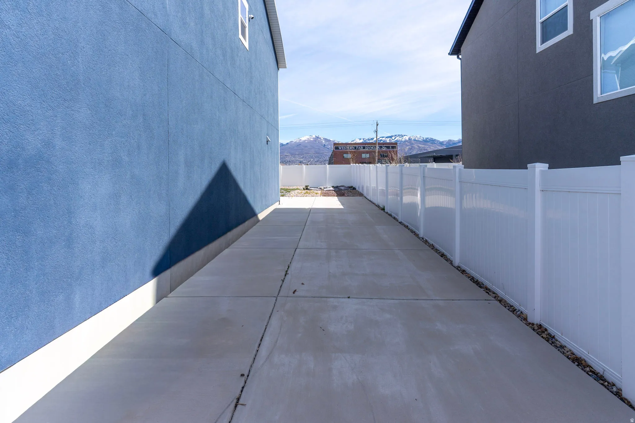 View of side of property featuring a mountain view, a fenced backyard, and a patio area