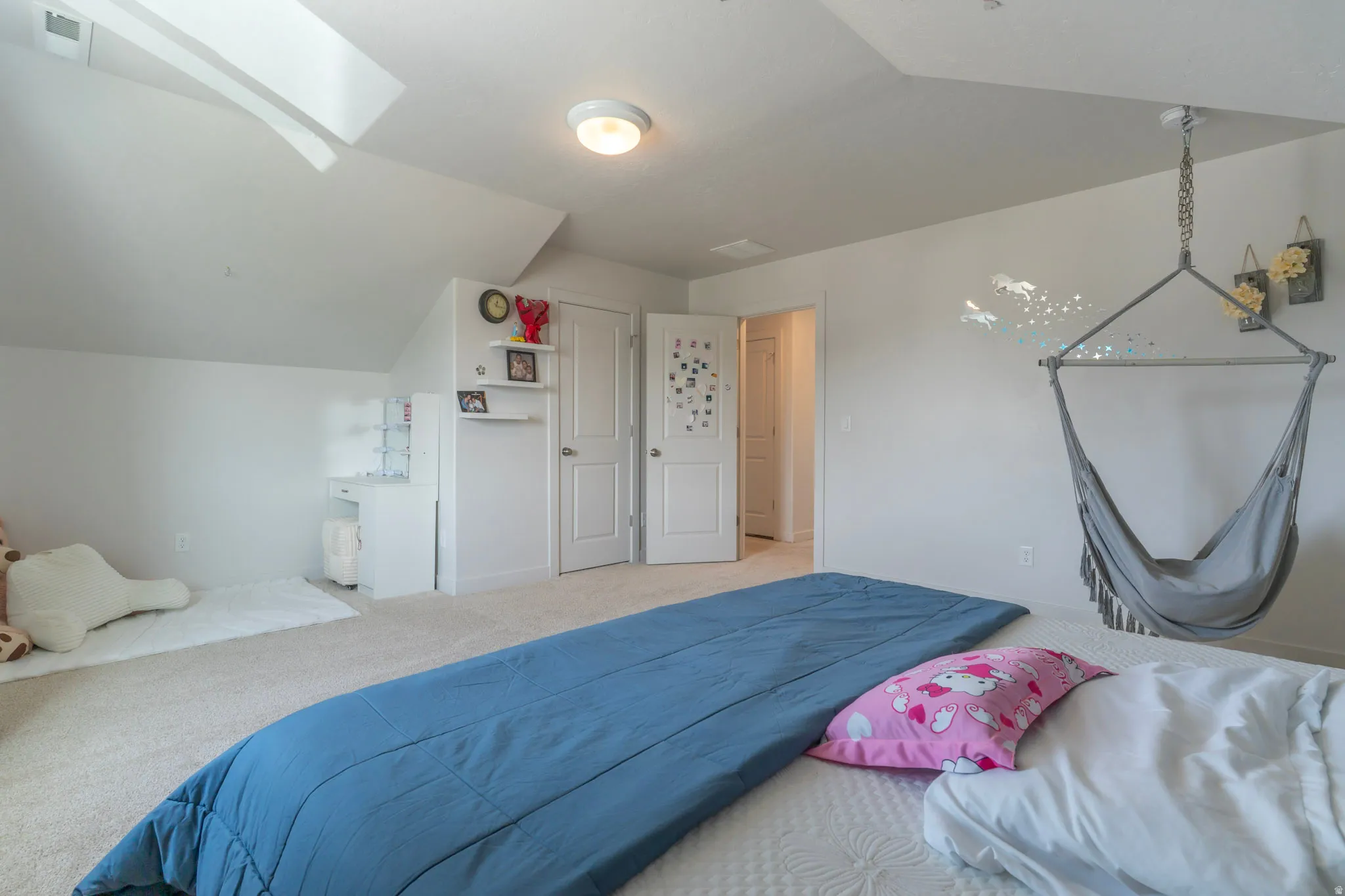 Carpeted bedroom with vaulted ceiling and a skylight