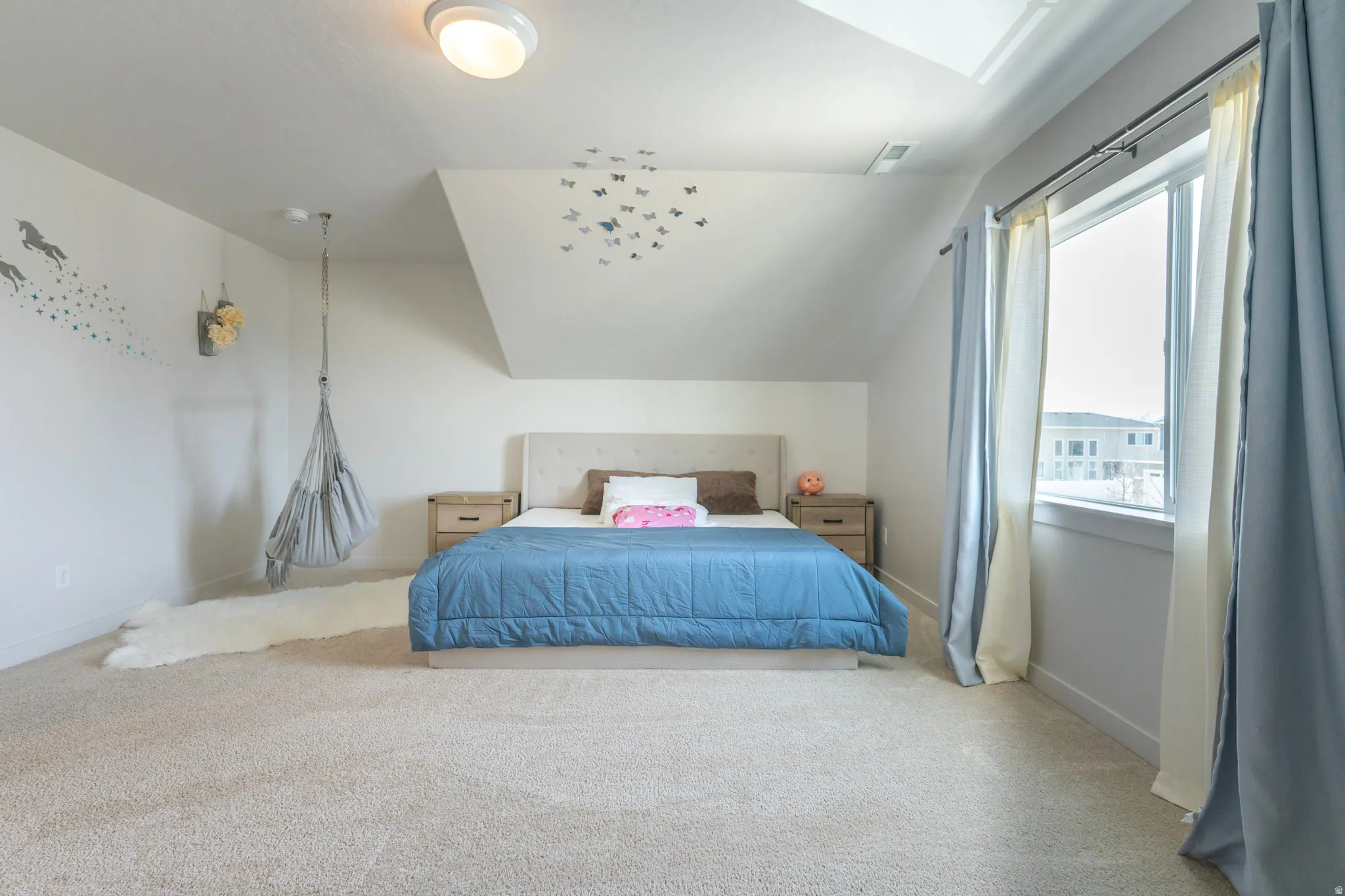 Carpeted bedroom featuring vaulted ceiling and baseboards