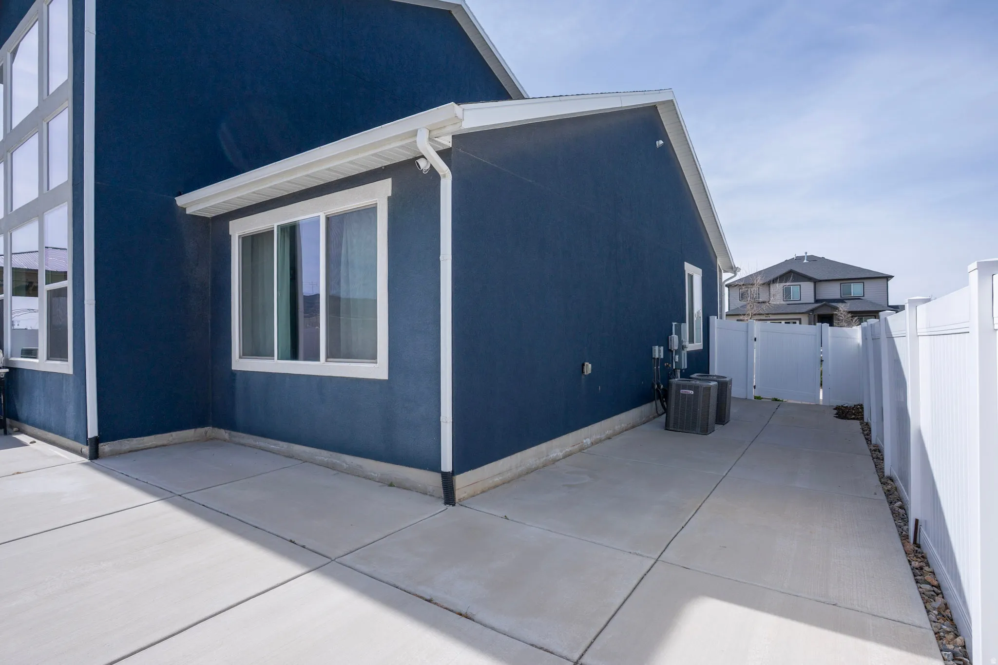 View of property exterior featuring a gate, a fenced backyard, and stucco siding