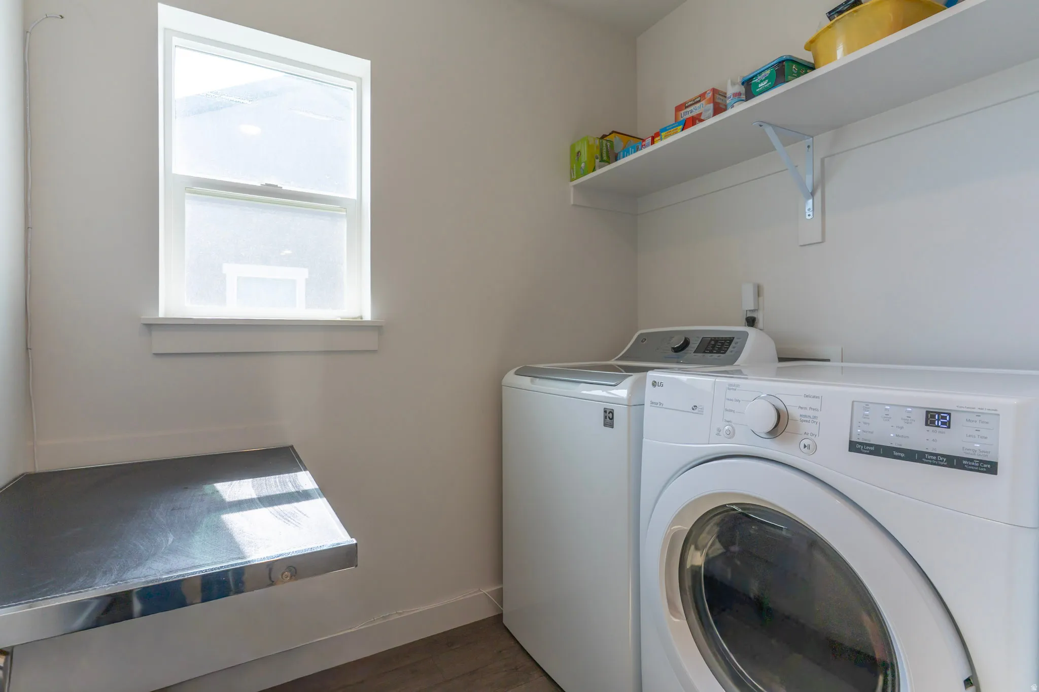 Laundry room with dark wood-style floors and washing machine and dryer