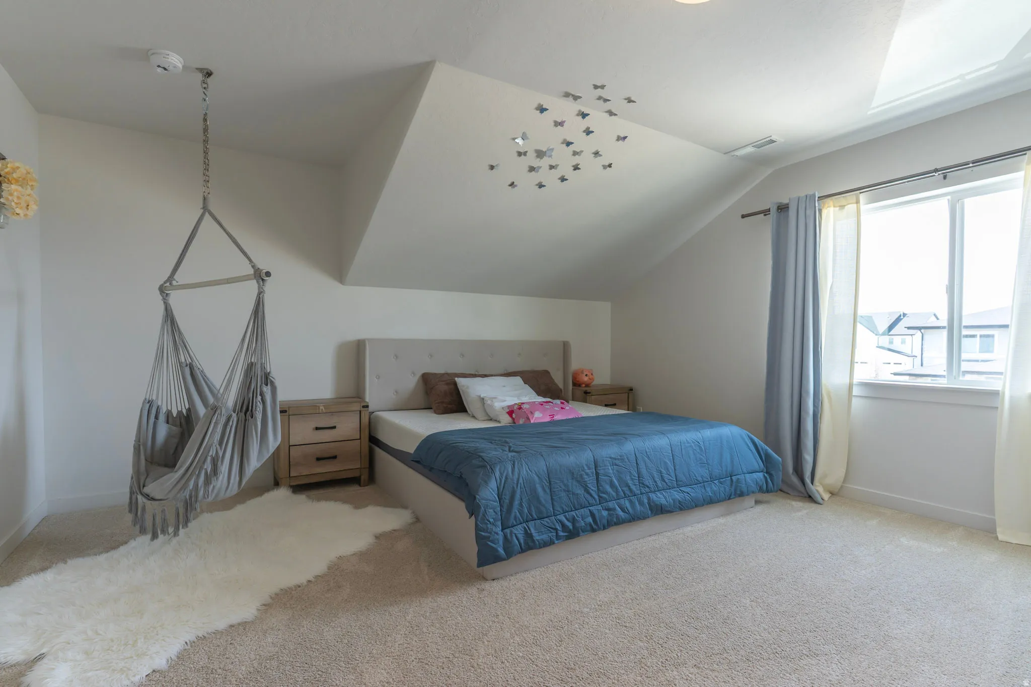 Carpeted bedroom with vaulted ceiling and baseboards