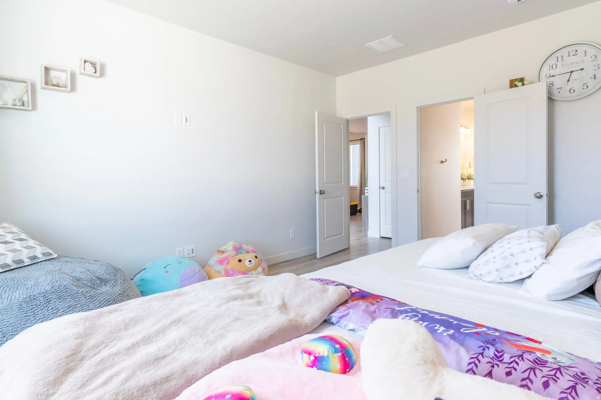 Bedroom with wood finished floors and connected bathroom