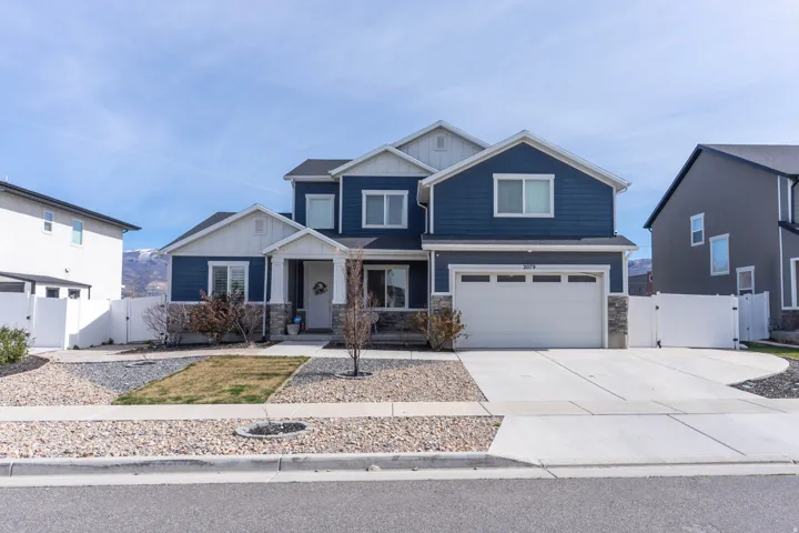 Craftsman inspired home featuring a gate, stone siding, a garage, and driveway