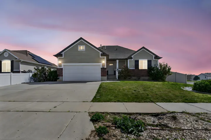 View of front facade with brick siding, concrete driveway, and an attached garage