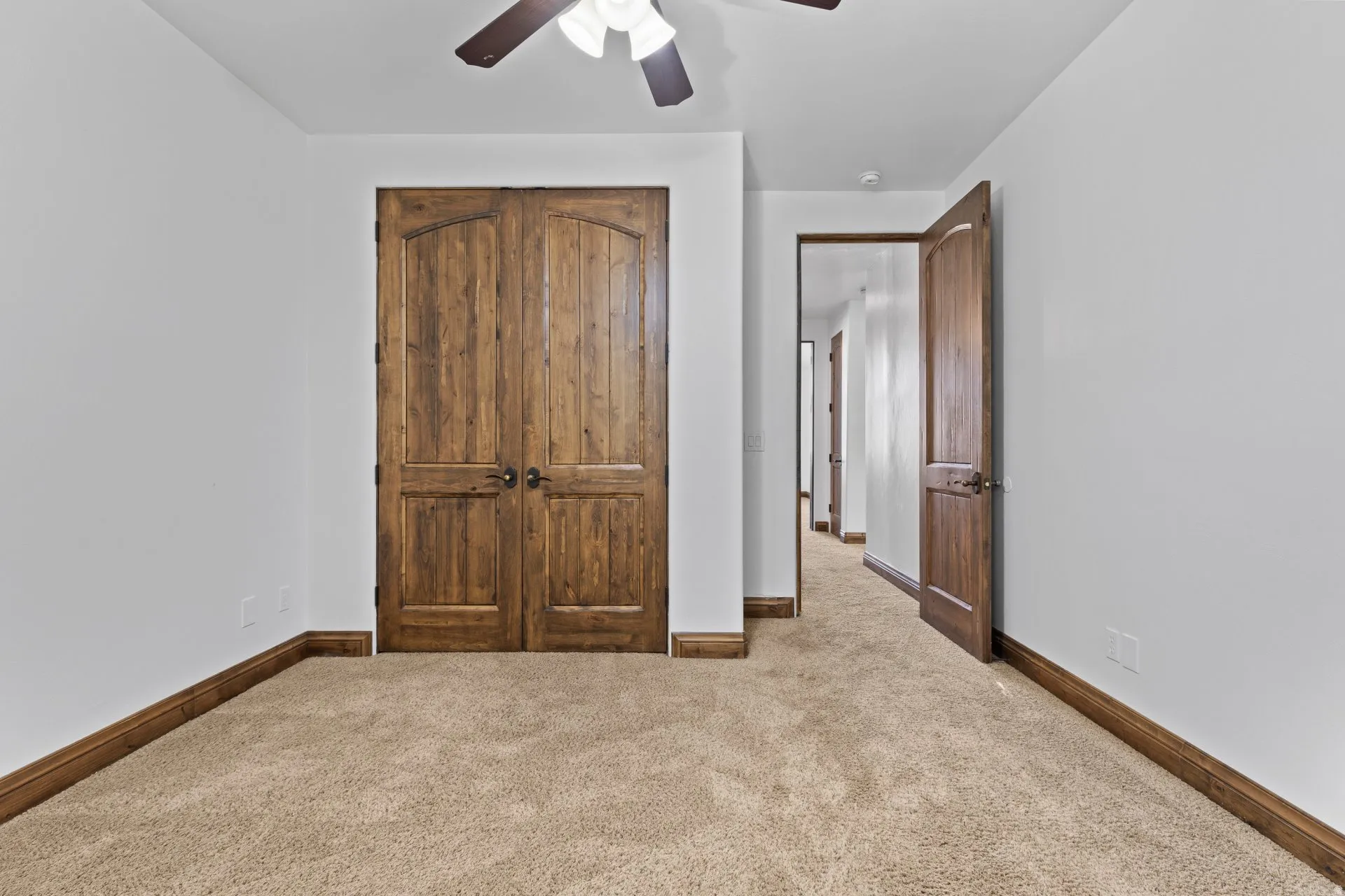 Unfurnished bedroom featuring carpet floors, a closet, and a ceiling fan