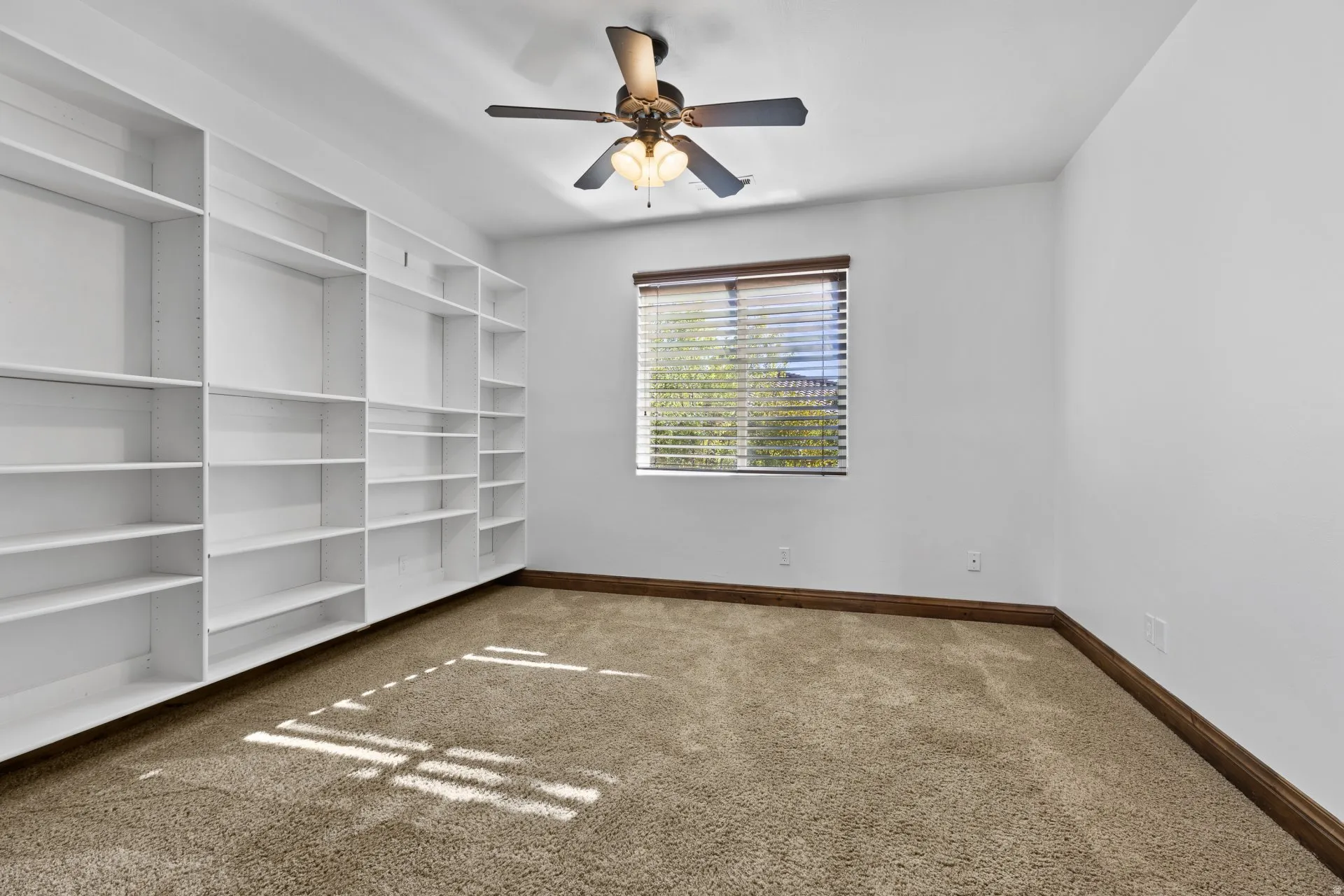 Empty room with carpet floors and ceiling fan