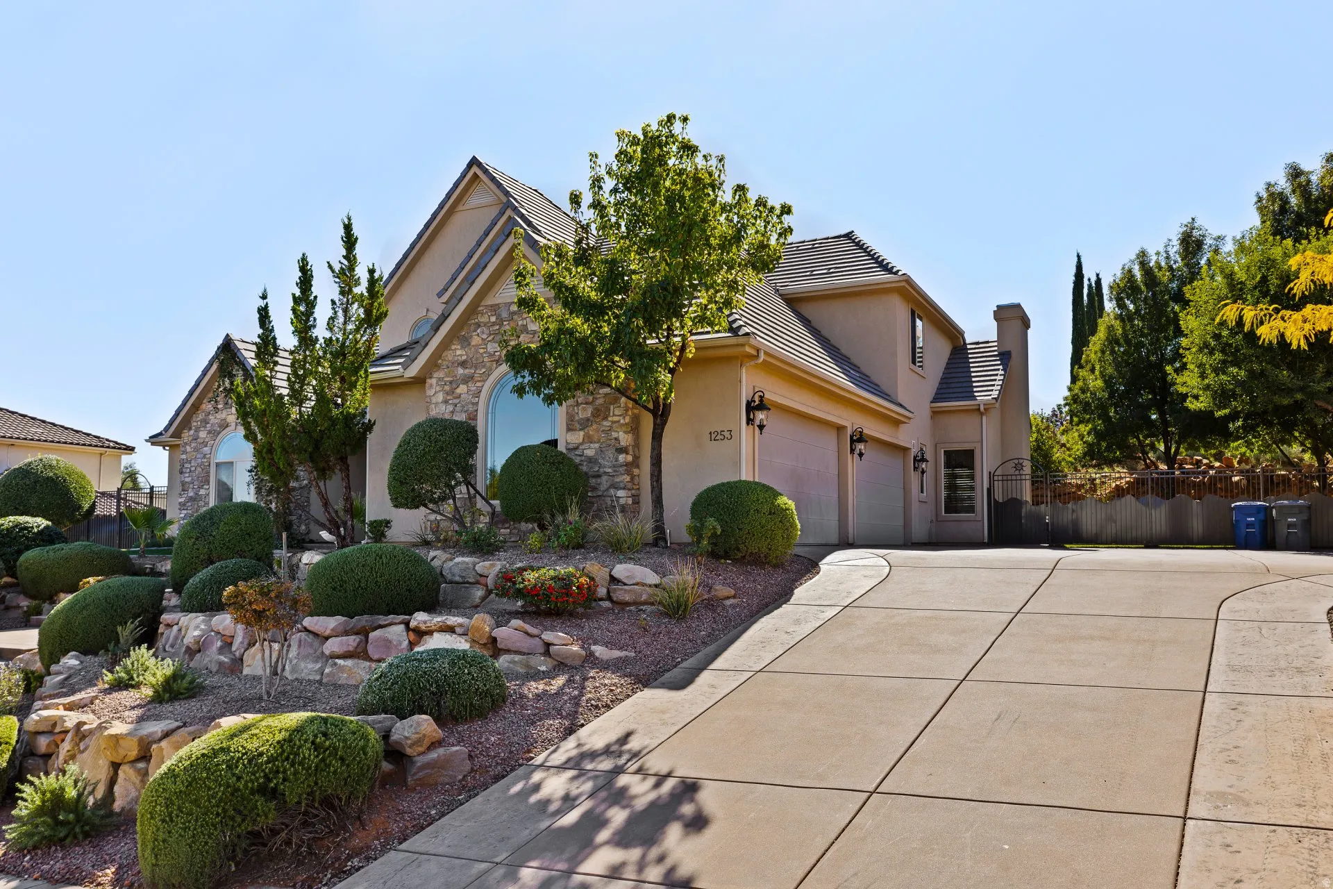 View of front of property featuring stone siding, stucco siding, a garage, and concrete driveway