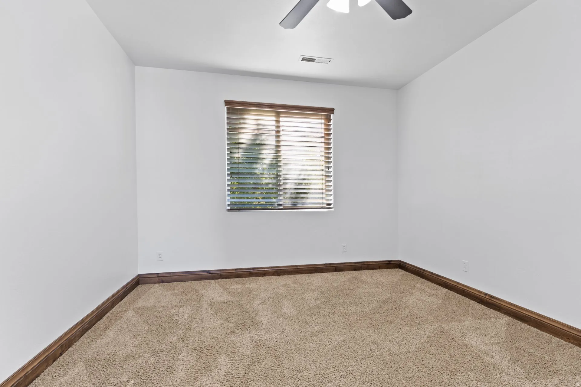 Empty room with carpet flooring and a ceiling fan