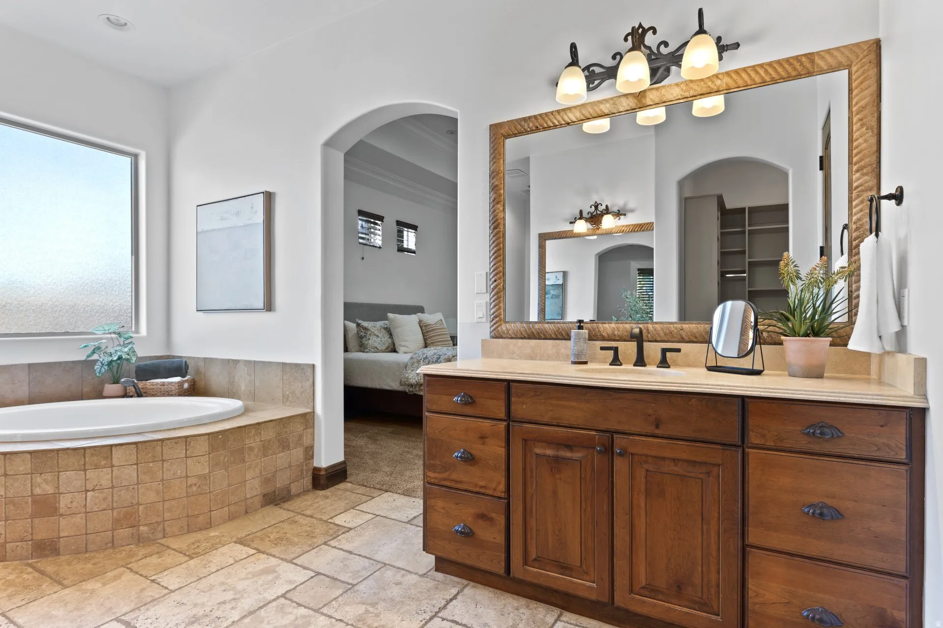 Ensuite bathroom with stone tile flooring, vanity, and a garden tub