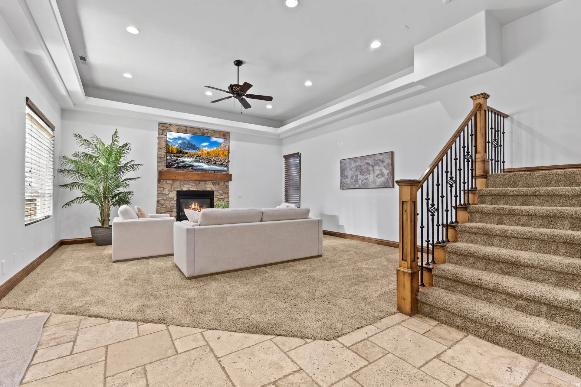 Living area featuring stone tile flooring, a fireplace, ceiling fan, and recessed lighting