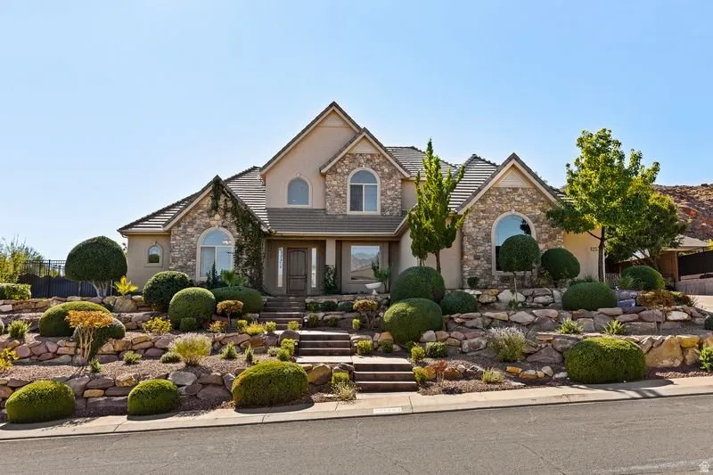 Traditional home with stone siding, stucco siding, and a tiled roof